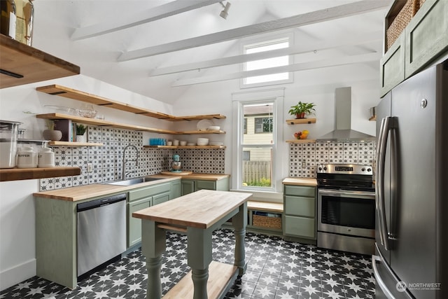 kitchen with extractor fan, sink, wooden counters, green cabinetry, and stainless steel appliances