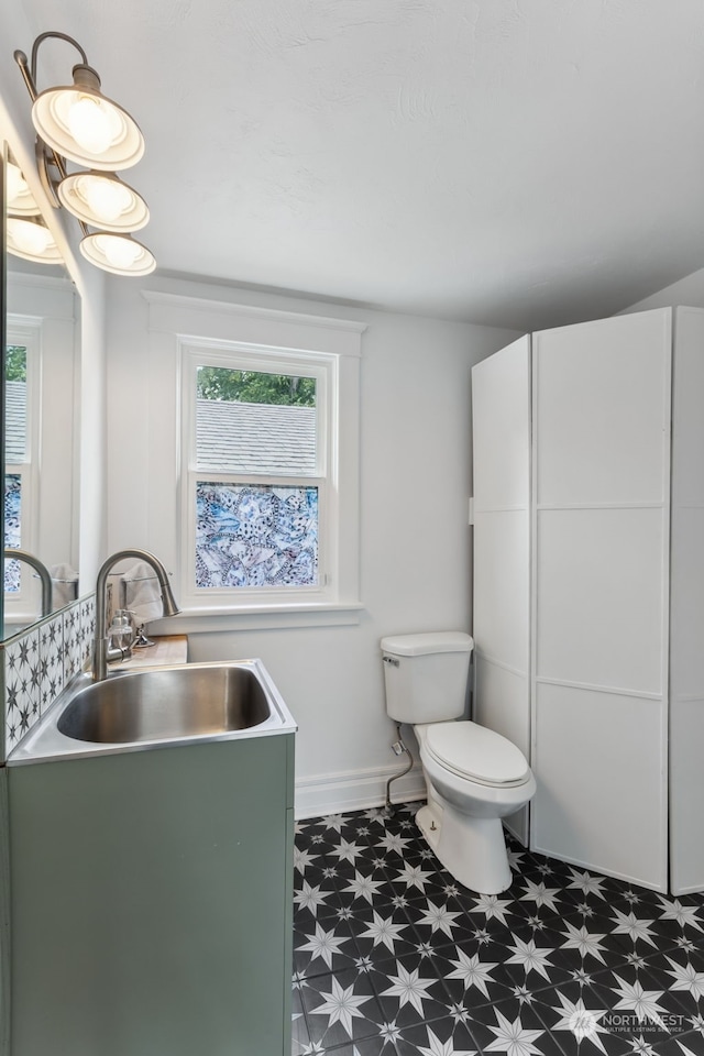 bathroom with plenty of natural light, toilet, and sink