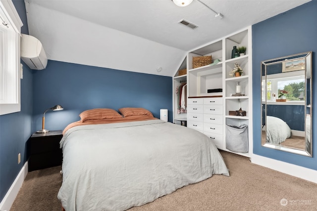 carpeted bedroom with vaulted ceiling and a wall unit AC