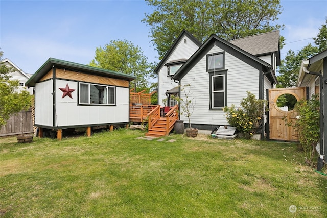 rear view of property with a wooden deck and a lawn