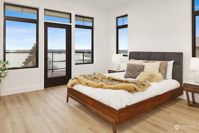 bedroom with light hardwood / wood-style flooring and access to outside