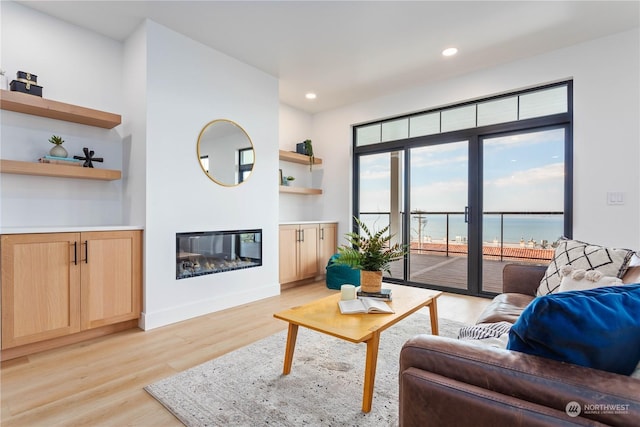 living room with a water view and light wood-type flooring