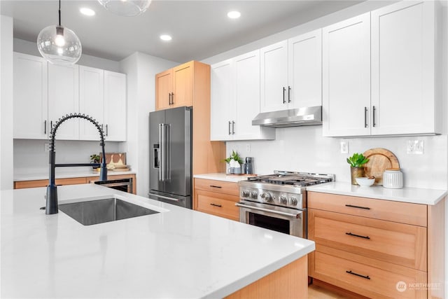 kitchen featuring sink, high end appliances, hanging light fixtures, light brown cabinets, and white cabinets