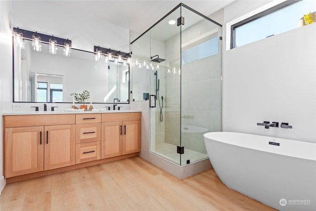 bathroom with vanity, hardwood / wood-style floors, and separate shower and tub