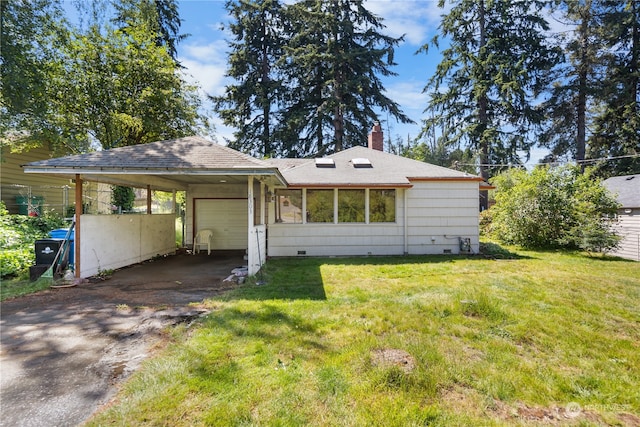 back of house featuring a carport and a lawn