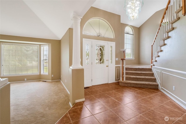 entryway featuring a wealth of natural light, high vaulted ceiling, dark carpet, and an inviting chandelier