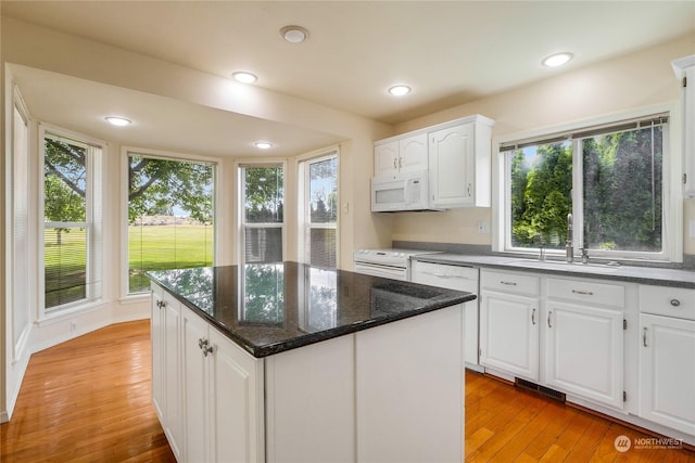 kitchen with white cabinetry, light hardwood / wood-style flooring, a center island, and plenty of natural light