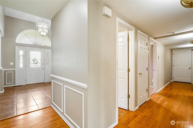 entryway with hardwood / wood-style flooring and a notable chandelier