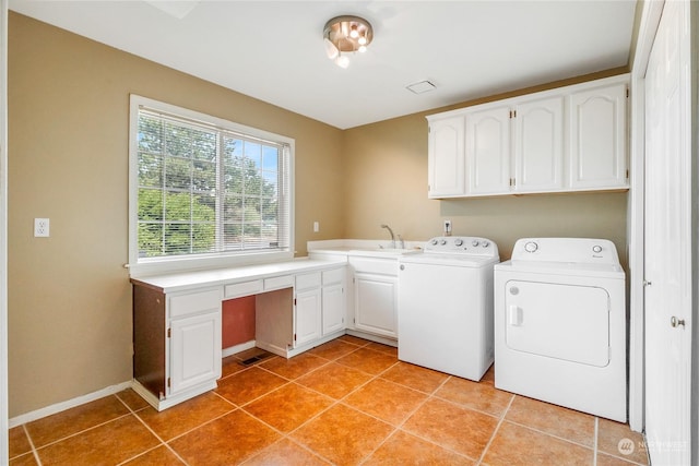 laundry area featuring cabinets, light tile patterned floors, sink, and washing machine and clothes dryer