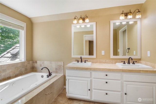 bathroom featuring tile patterned floors, vanity, lofted ceiling, and tiled bath