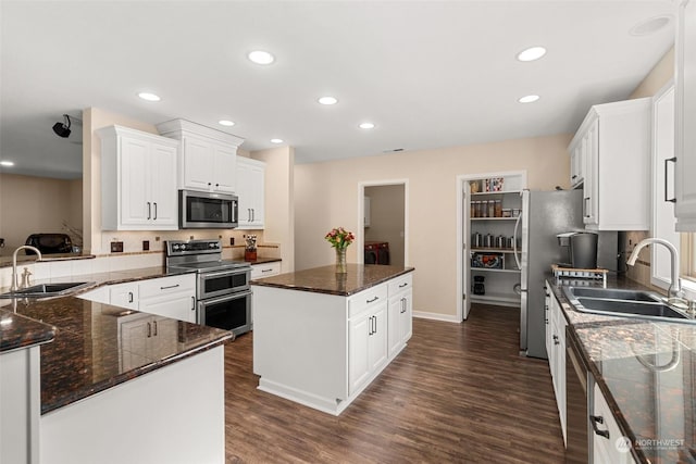 kitchen featuring white cabinetry, sink, a center island, and appliances with stainless steel finishes