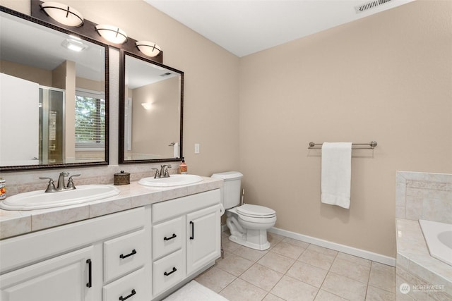 bathroom with tile patterned floors, toilet, vanity, and tiled tub