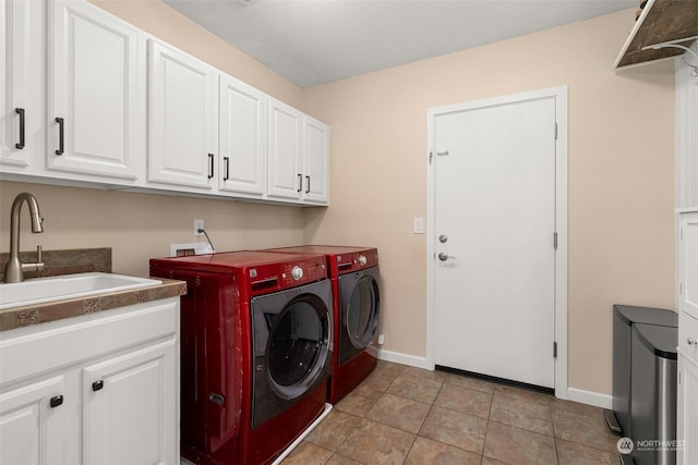 laundry area with washer and clothes dryer, light tile patterned floors, cabinets, and sink