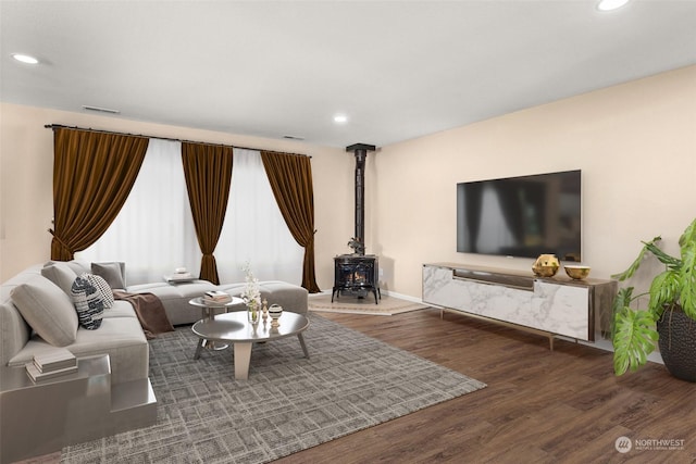 living room with dark hardwood / wood-style flooring and a wood stove