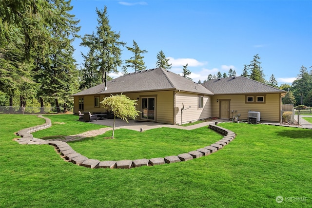 back of house with a patio area and a lawn