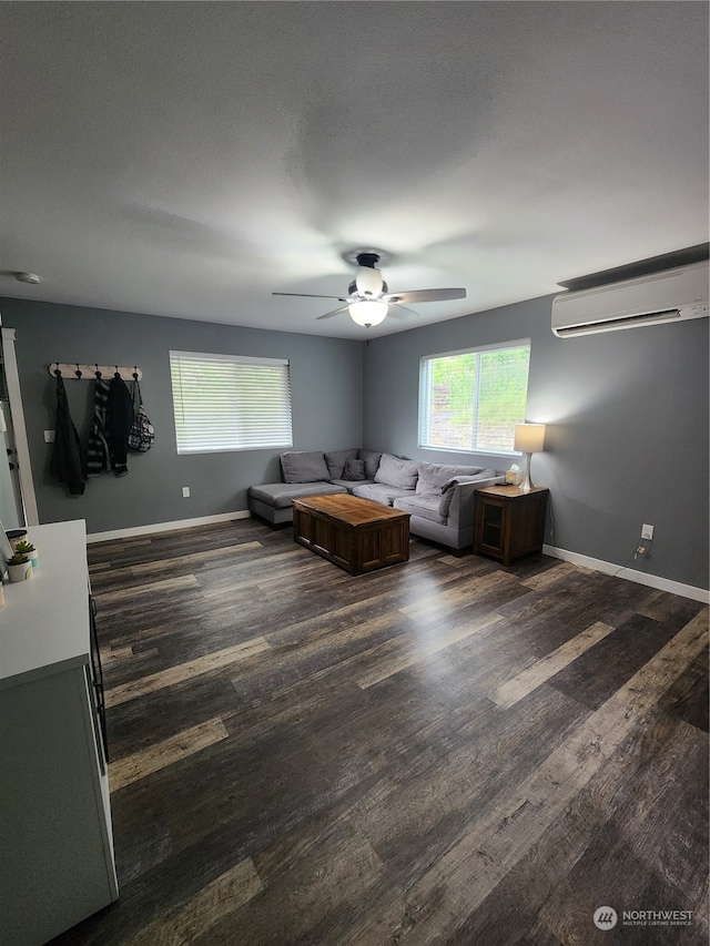 unfurnished living room with ceiling fan, dark hardwood / wood-style flooring, and a wall mounted AC