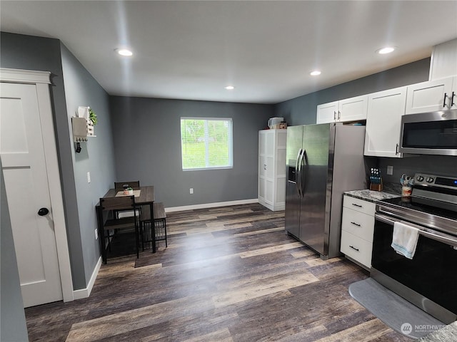 kitchen featuring white cabinetry, dark wood-type flooring, baseboards, and appliances with stainless steel finishes