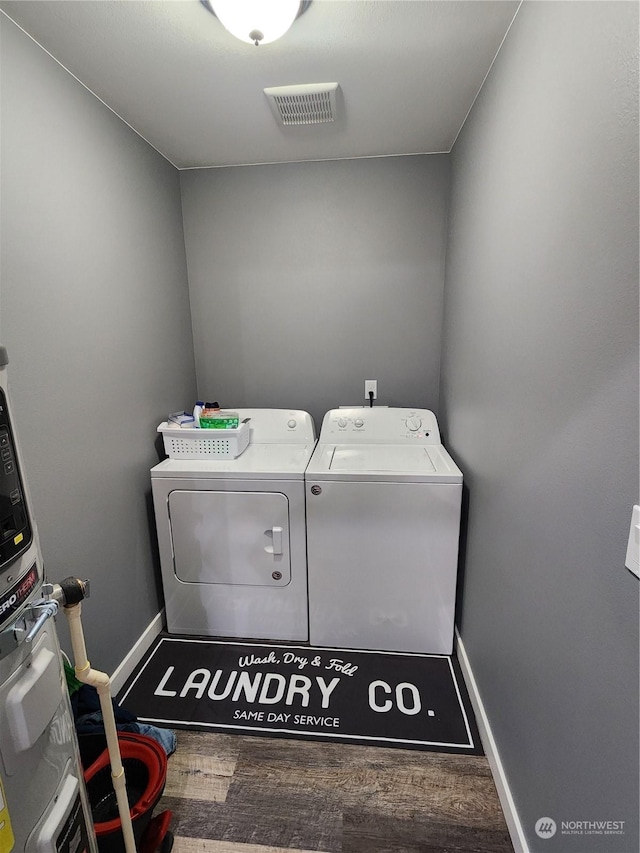 laundry room featuring wood finished floors, visible vents, baseboards, laundry area, and independent washer and dryer