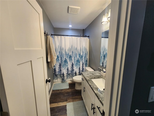 full bathroom featuring visible vents, toilet, a shower with shower curtain, wood finished floors, and vanity