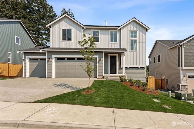 view of front facade featuring a front yard, fence, board and batten siding, and driveway