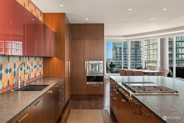 kitchen featuring appliances with stainless steel finishes, dark hardwood / wood-style floors, sink, and a wealth of natural light