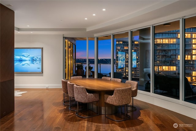 dining area with hardwood / wood-style flooring and a water view