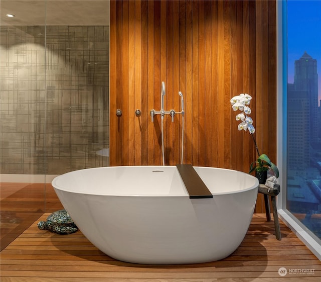 bathroom with wood-type flooring and a washtub