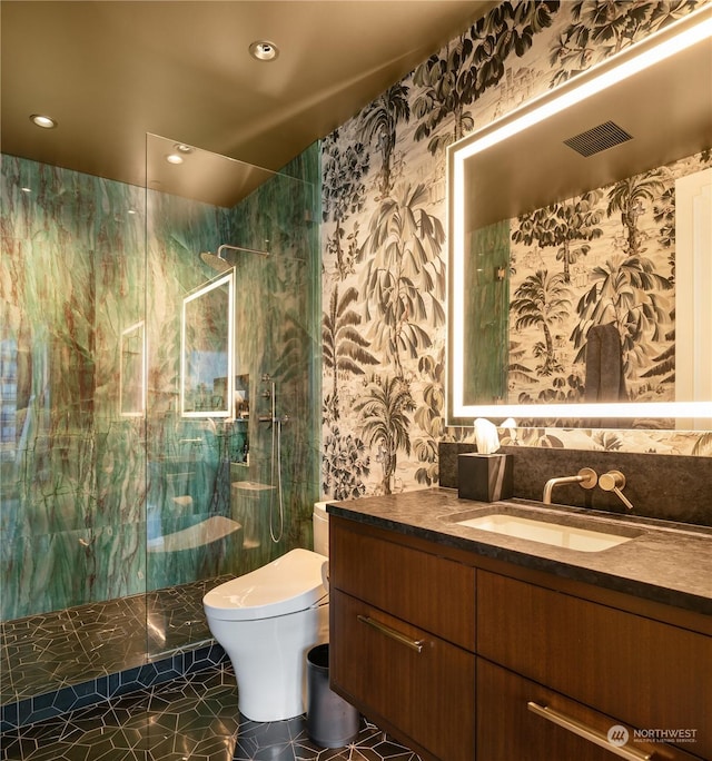 bathroom with tiled shower, tile patterned floors, vanity, and toilet