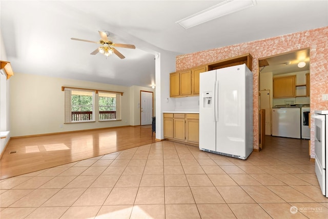 kitchen with white refrigerator with ice dispenser, light tile patterned floors, separate washer and dryer, and ceiling fan