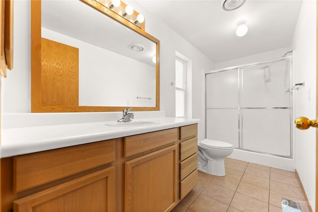 bathroom with tile patterned flooring, vanity, toilet, and walk in shower