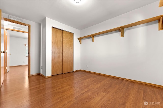 unfurnished bedroom with hardwood / wood-style floors and a closet