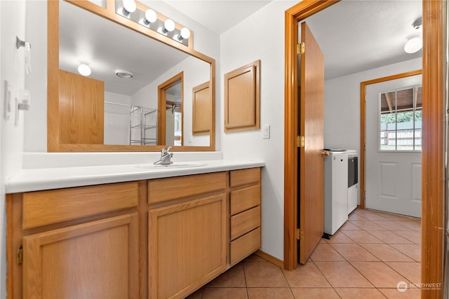 bathroom featuring tile patterned flooring, vanity, and independent washer and dryer