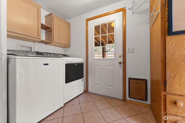 laundry area featuring cabinets, light tile patterned floors, and washing machine and dryer