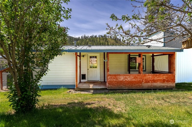 rear view of house with a lawn and covered porch