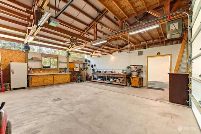 garage featuring a workshop area and white refrigerator