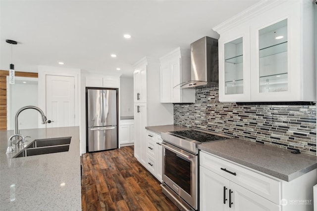 kitchen with wall chimney exhaust hood, sink, white cabinetry, and stainless steel appliances