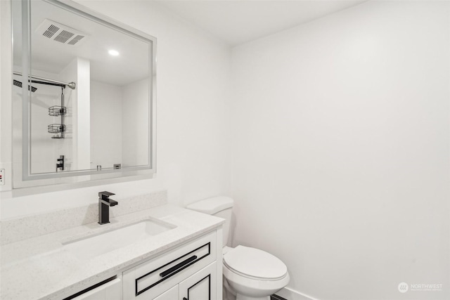 bathroom with walk in shower, vanity, and toilet