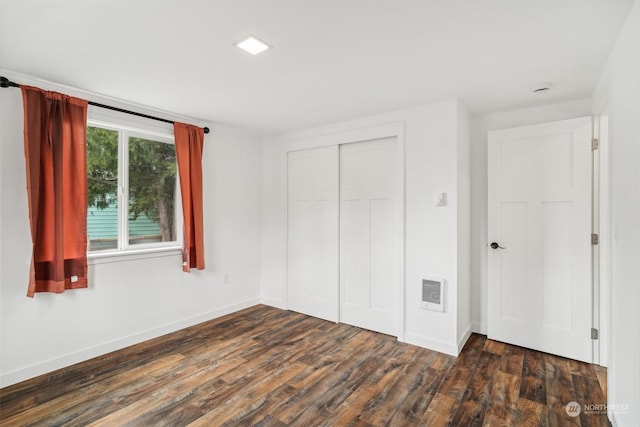 unfurnished bedroom featuring dark hardwood / wood-style flooring and a closet