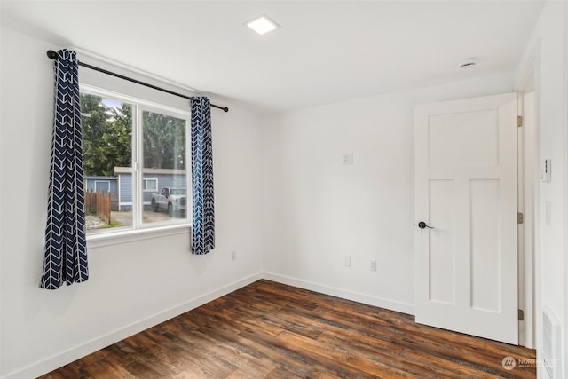 spare room with plenty of natural light and dark hardwood / wood-style floors