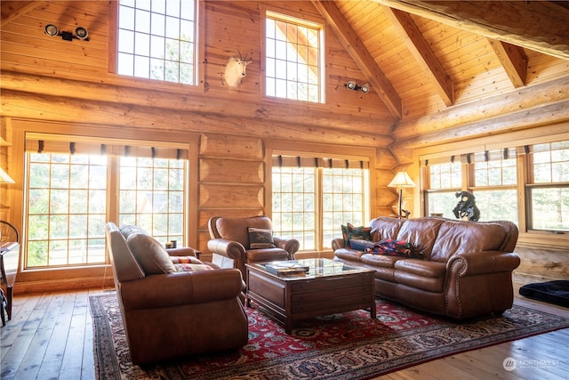 living room featuring beam ceiling, log walls, hardwood / wood-style floors, wooden ceiling, and high vaulted ceiling