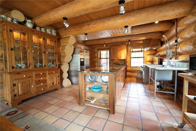 kitchen with wood ceiling, light tile patterned floors, rustic walls, a kitchen island, and beam ceiling