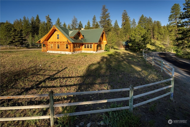 back of property with a lawn and a rural view