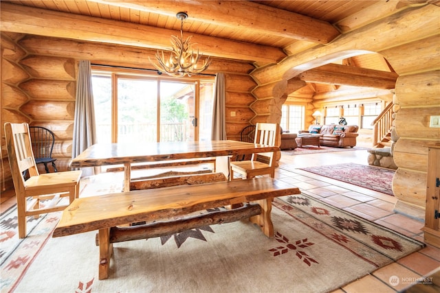 tiled dining space featuring a notable chandelier, beam ceiling, wooden ceiling, and rustic walls