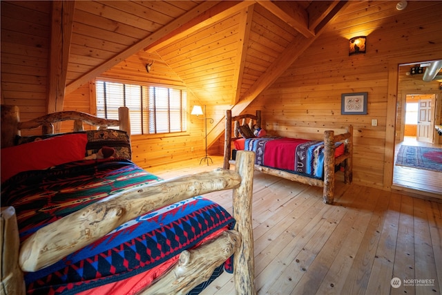 bedroom with wood-type flooring, lofted ceiling with beams, multiple windows, and wooden ceiling