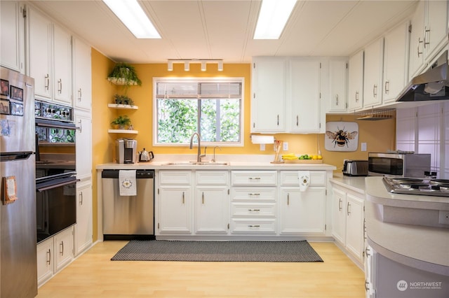 kitchen with white cabinets, sink, light wood-type flooring, and stainless steel appliances