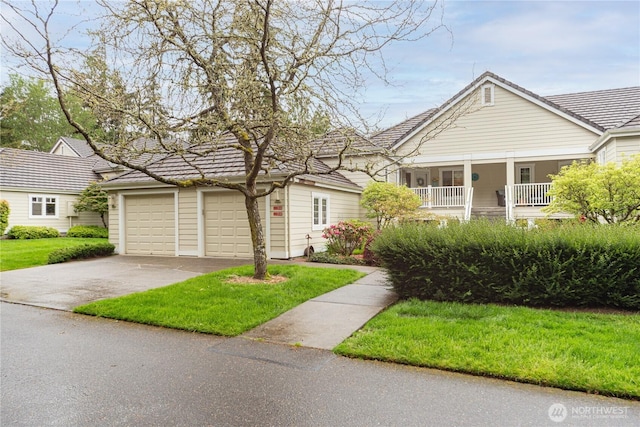 view of front of house featuring a porch, a front yard, and a garage