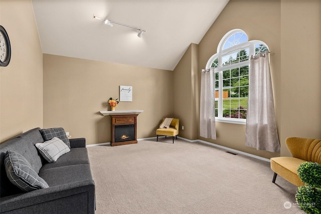 living area with rail lighting, carpet floors, and lofted ceiling