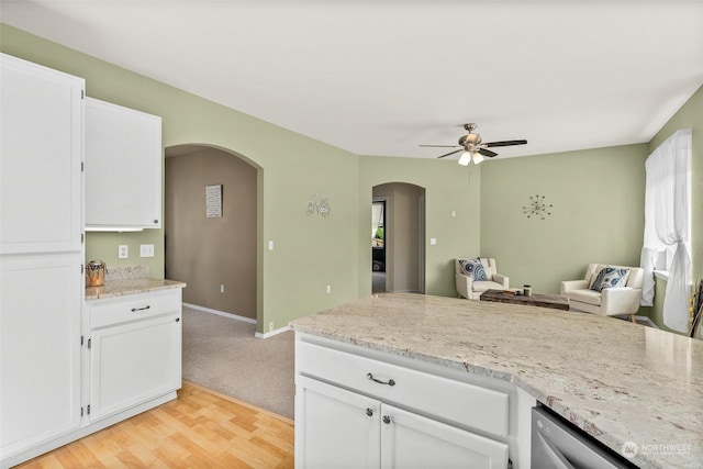 kitchen featuring white cabinetry, ceiling fan, light stone counters, and light wood-type flooring