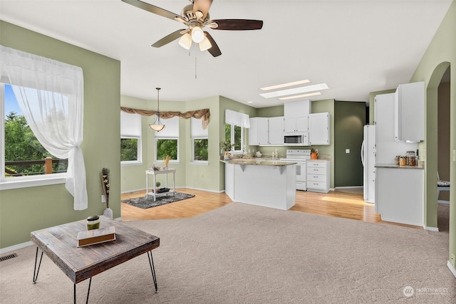 carpeted living room featuring a wealth of natural light and ceiling fan