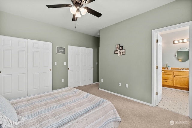 bedroom featuring light carpet, connected bathroom, ceiling fan, and sink